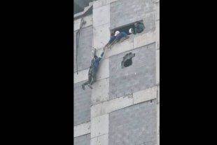 Operário fica pendurado no alto de um prédio e é resgatado por seus companheiros de trabalho